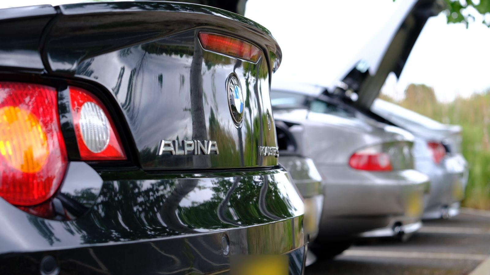 Rear of a black Alpina Roadster with other Z4s parked behind