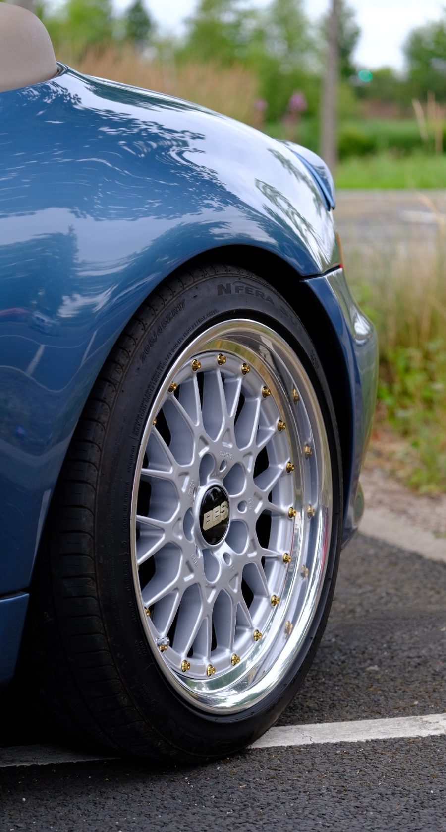 Polished BBS wheel with gold bolts on a blue Z3