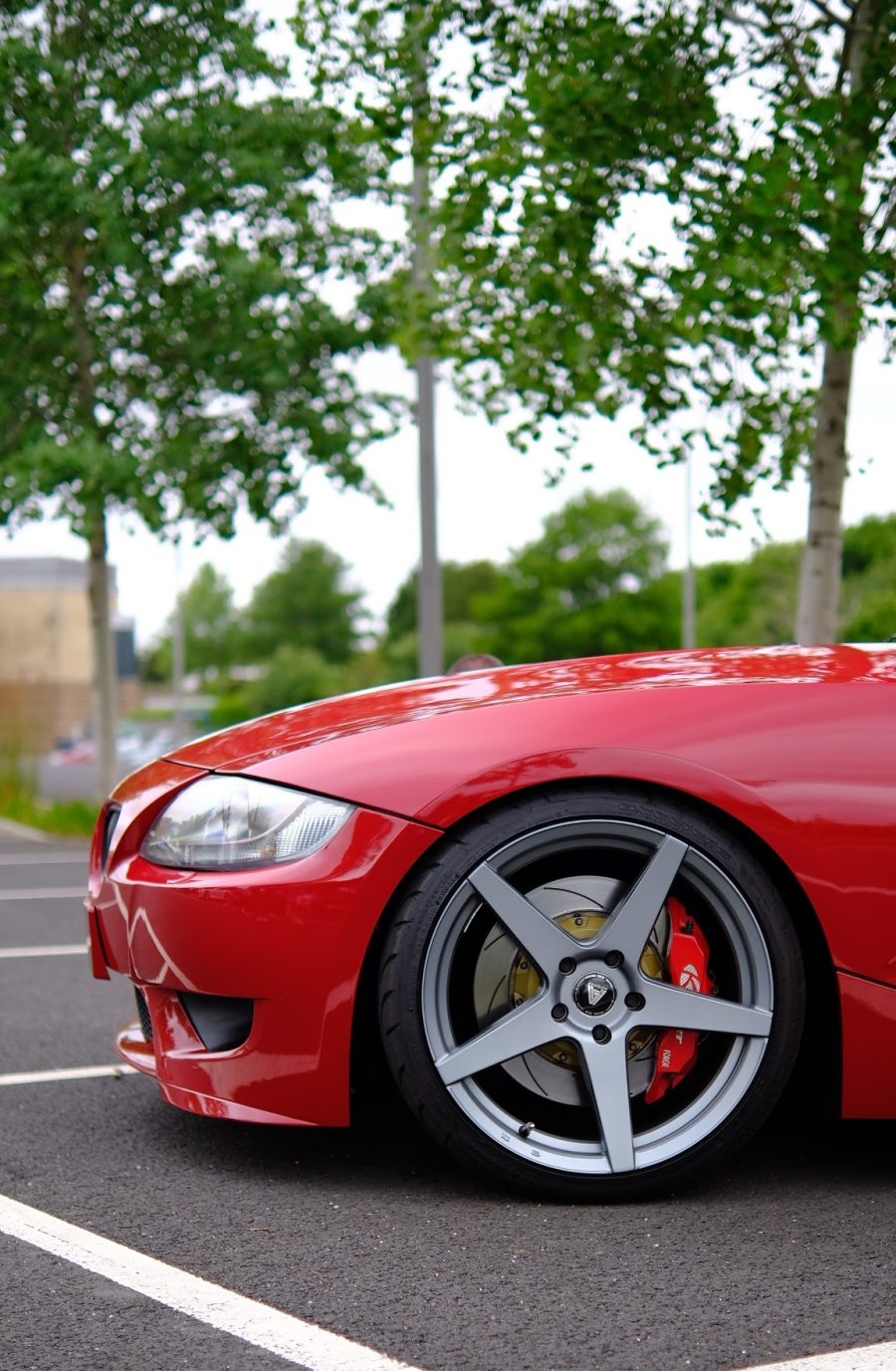 Red Z4 front corner with a grey five-spoke wheel and red brake caliper